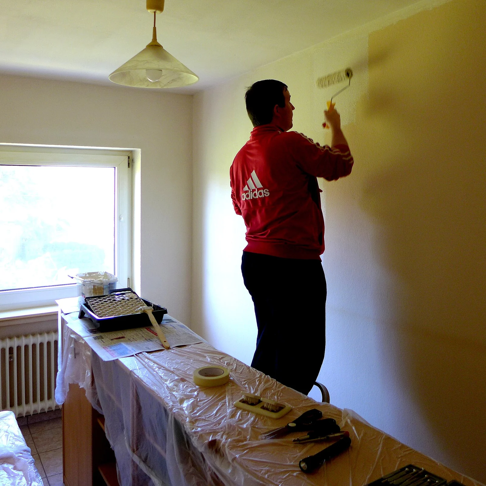 Application de peinture sur un mur intérieur.